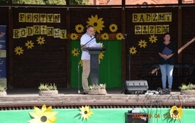 Osoba na scenie przemawiająca przed m&oacute;wnicą