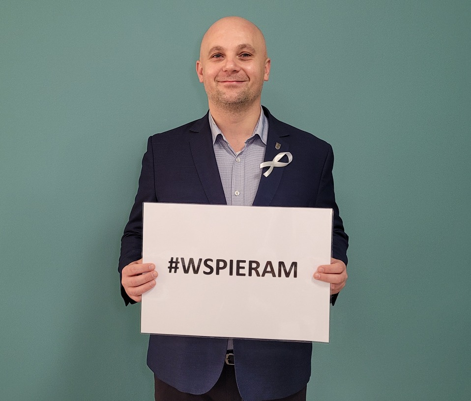 Kierownik CEOiS Patryciusz Migawa trzymający kartkę z napisem #Wspieram